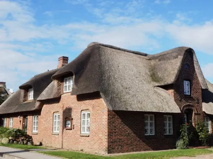 Reetgedecktes Friesenhaus aus rotem Klinker in Nordfriesland